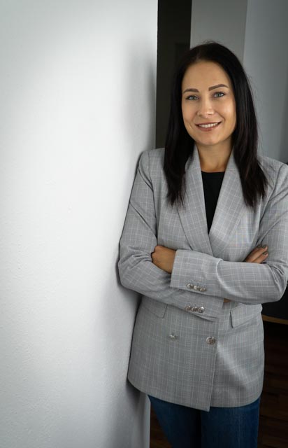 lächelnde Frau lehnt an Wand